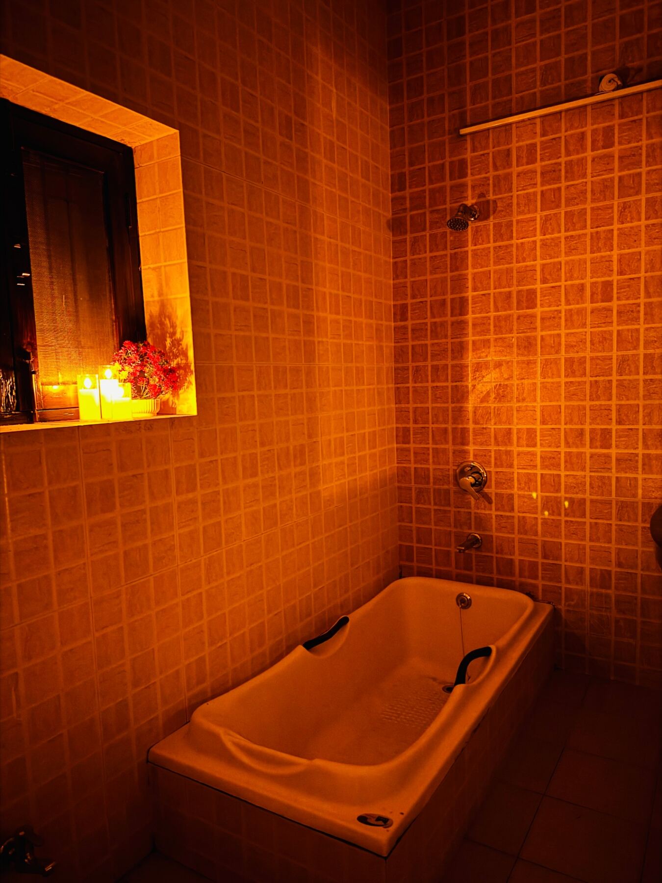 Candlelit bathtub with floral arrangement